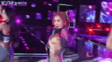 a group of women are dancing on a stage in front of a purple background .