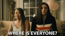 two women sitting on a couch with the words " where is everyone " in front of them
