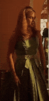 the woman is wearing a green dress and a headband .