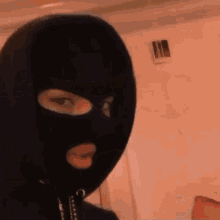 a person wearing a black ski mask with a hole in it .