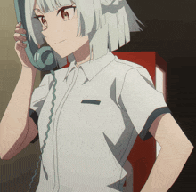 a girl in a white shirt is talking on a telephone