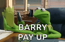 kermit the frog is sitting at a desk looking at a cell phone and saying barry pay up