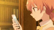 a girl with a ponytail is looking at a cell phone with the letter r on it