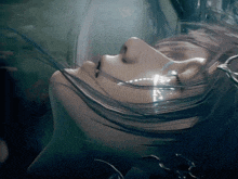 a close up of a woman 's face with water coming out of her mouth