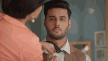 a woman is helping a man tie his bow tie