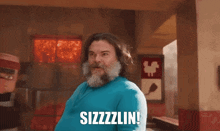 a man with a beard says sizzzzlin in a restaurant
