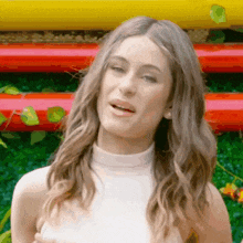 a woman wearing a white top is making a face