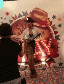 a woman in a cowboy outfit is being photographed by a cameraman