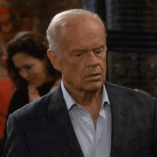 a man in a suit and white shirt is looking at something