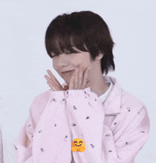 a person covering their face with their hands with a smiley face behind them