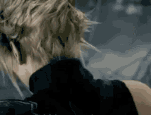 a close up of a person 's back with their head down and their hair blowing in the wind .