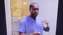 a man in a blue scrub top holds a bottle