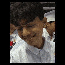 a young man in a graduation cap and gown smiles