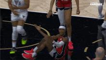a basketball player is sitting on the floor with a carmax logo in the corner