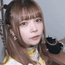 a close up of a girl 's face with a braid and earrings