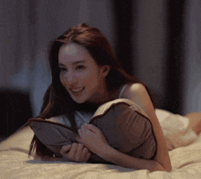 a woman laying on a bed with a pillow in her lap