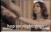 a woman is standing in front of a mirror with the words hop on nightreign written on the bottom .