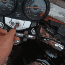 a person is holding a screwdriver in front of a honda dashboard