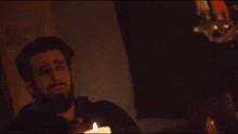 a man with a beard is laying down in the dark