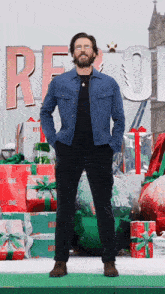 a man in a blue jacket stands in front of a sign that says red one