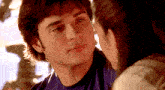a close up of a man 's face with a woman 's face behind him