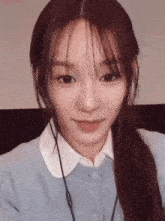 a close up of a girl wearing headphones and a blue sweater .