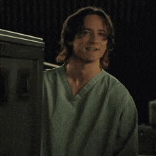a man in a green scrub top with the letter n on the left side of his chest