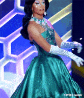 a woman in a green dress and white gloves is on a stage .