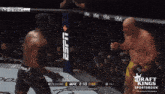 two men are fighting in a boxing ring sponsored by draft kings