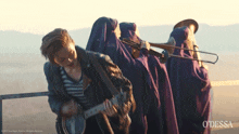 a man playing a guitar in front of a band with the word odessa on the bottom right