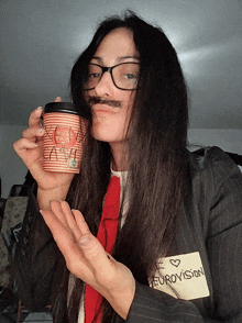 a woman with a fake mustache holds a cup of coffee