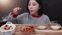 a girl is eating a slice of pizza with a fork