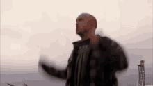 a man in a plaid jacket and a monster shirt is dancing in the air .