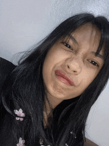 a girl with long black hair is making a funny face with her mouth open