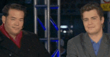 two men are sitting next to each other on a stage