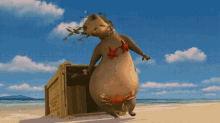 a hippopotamus with a starfish on its chest is standing next to a wooden box on a beach