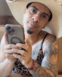 a man in a cowboy hat is holding a phone