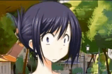 a girl with blue hair is making a funny face in a park with trees in the background .