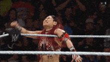 a woman in a wrestling ring with the letter w on the rope