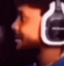 a blurry picture of a person wearing headphones with the letter g on the bottom