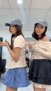 two girls wearing hats one of which says " i love you " on it