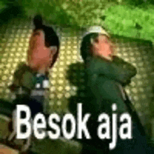 a couple of people standing next to each other with the words besok aja written on the bottom .