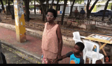 a woman holding a child 's hand while wearing a shirt that says ' kot ' on it