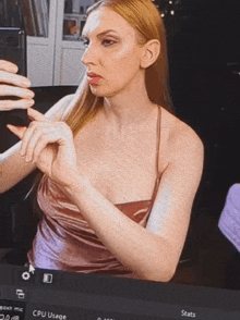a woman is taking a picture of herself in front of a screen that says stats