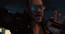 a man wearing sunglasses and a black suit is dancing