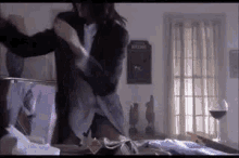 a man in a suit is standing next to a woman in a bedroom .