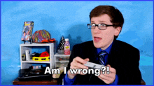 a man in a suit and tie holds a video game controller and says am i wrong