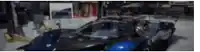 a blue and black car is parked in a garage .