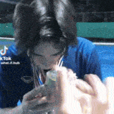 a man wearing a medal around his neck is drinking from a bottle ..