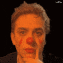 a close up of a man 's face with a red clown nose and the word luma on the bottom